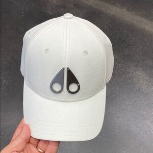 Moose Knuckles Ivory Hat with Metallic Emblem